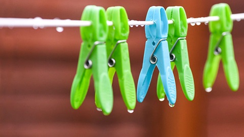 groene en blauwe knijpers hangen buiten aan de lijn in de regen